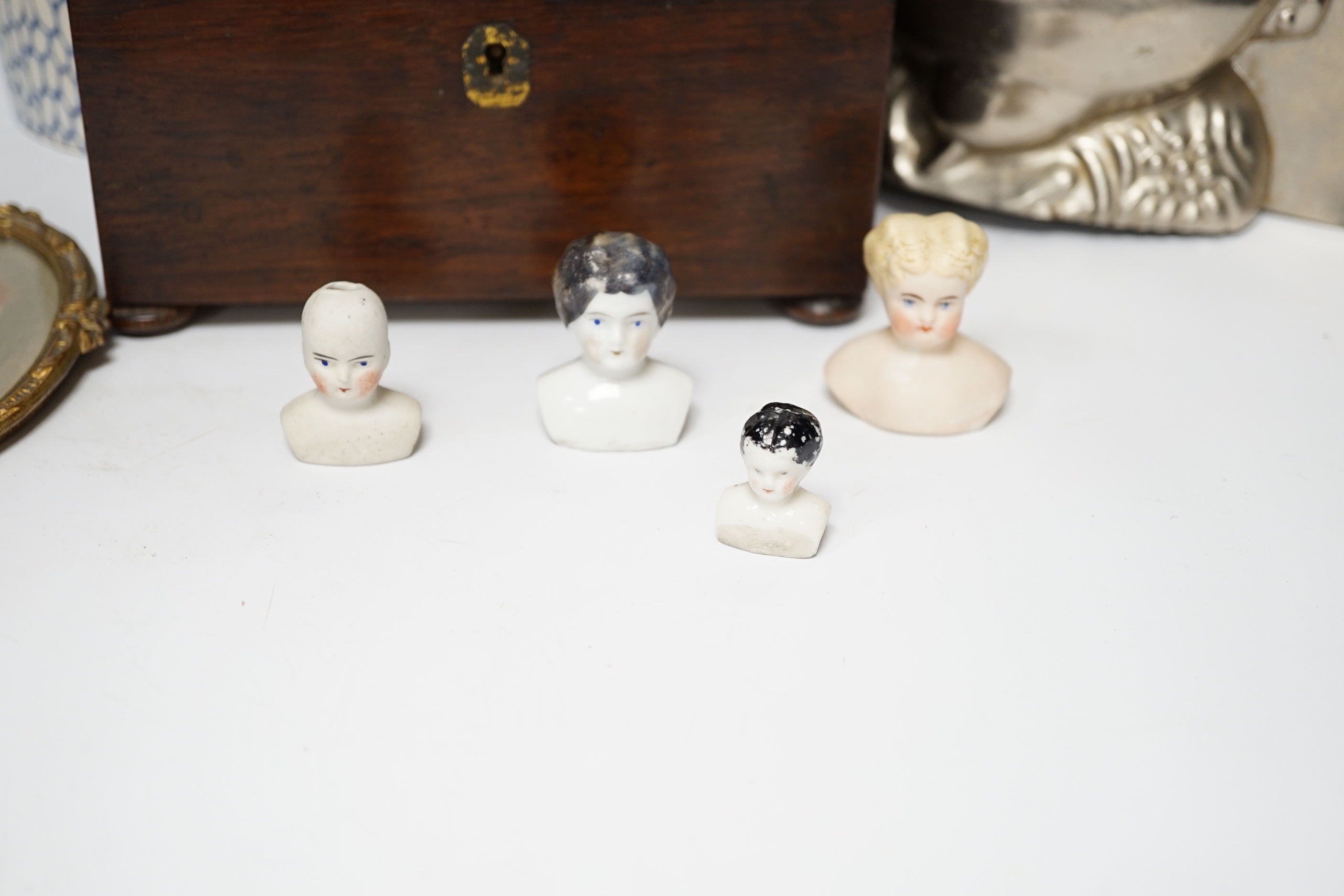 A novelty duck jelly mould, a pottery canister, a tea caddy, miniature dolls heads and a table lamp base, largest 34cm high